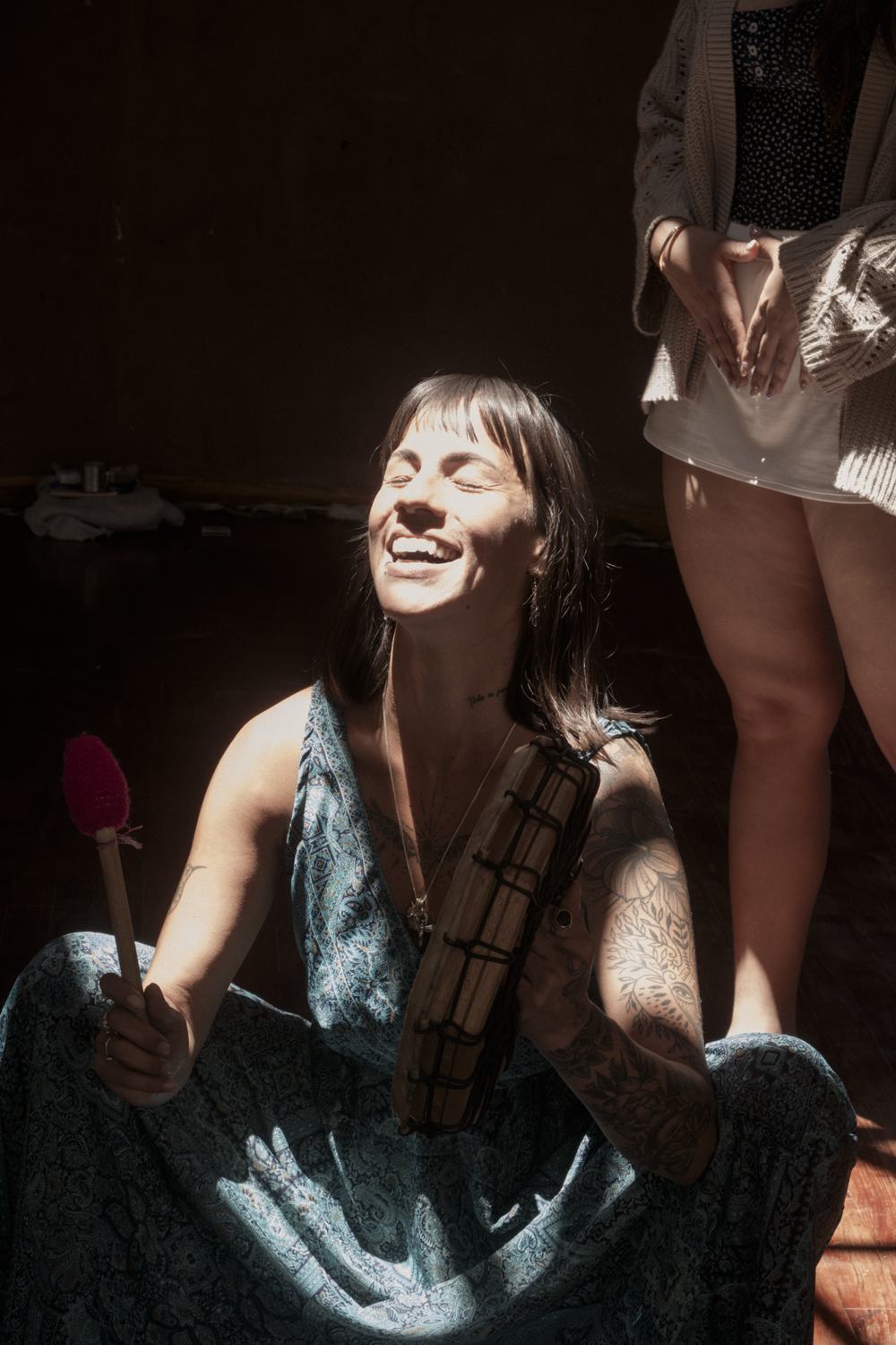 Ceci riendo con su tambor bajo un rayo de sol